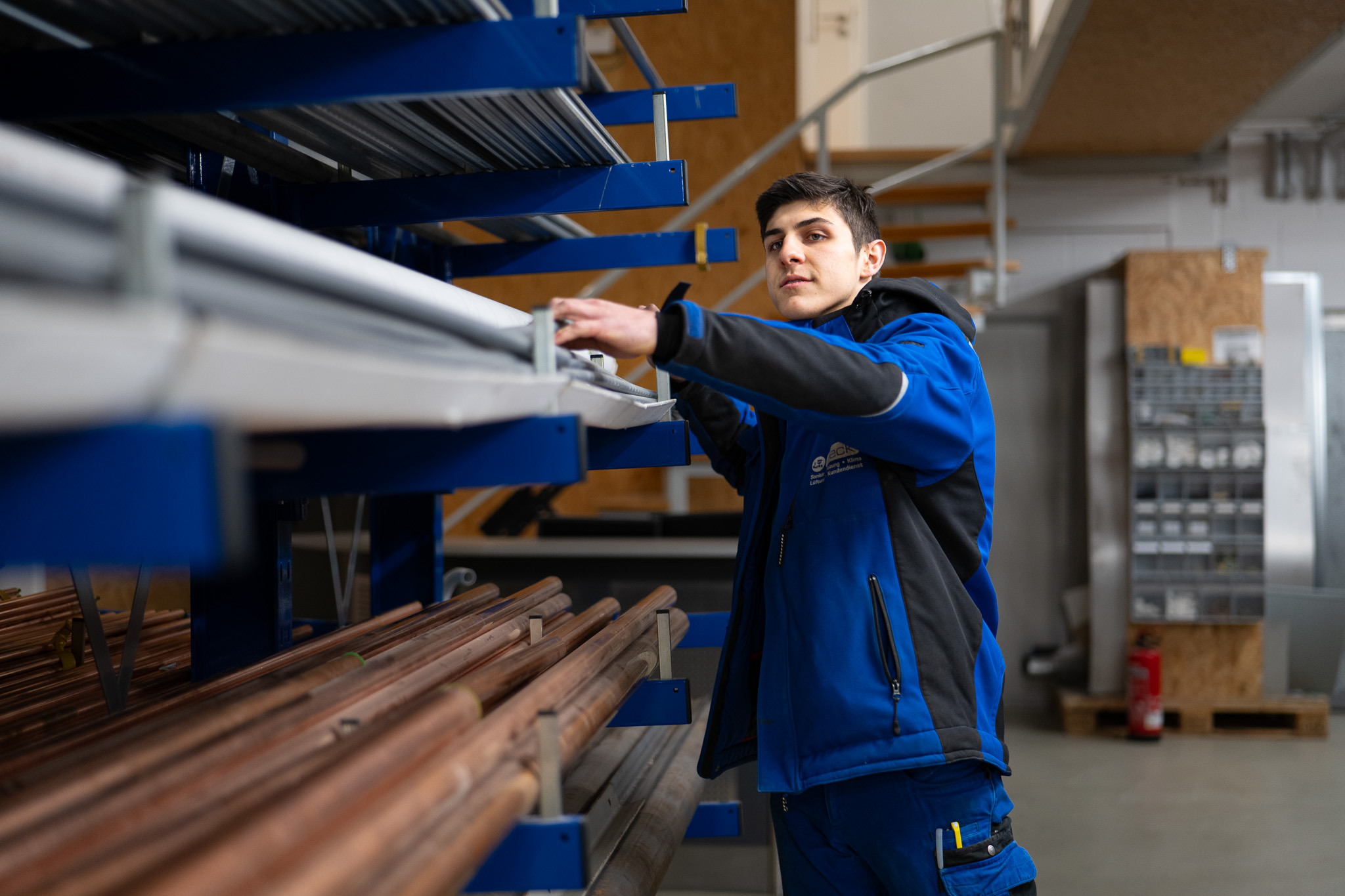 Beck-Mitarbeiter entnimmt Kupferrohre aus dem Materiallager
